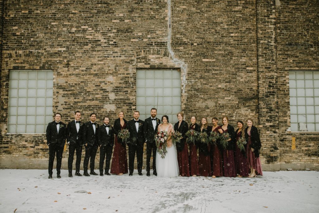 Milwaukee wedding party in front of Cream City Brick in winter.