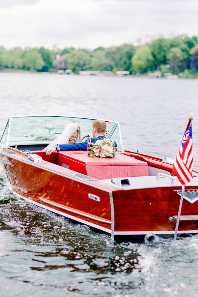 Bride and groom leaving their ceremony on a boat in East Troy Wisconsin on Lake Beulah. 