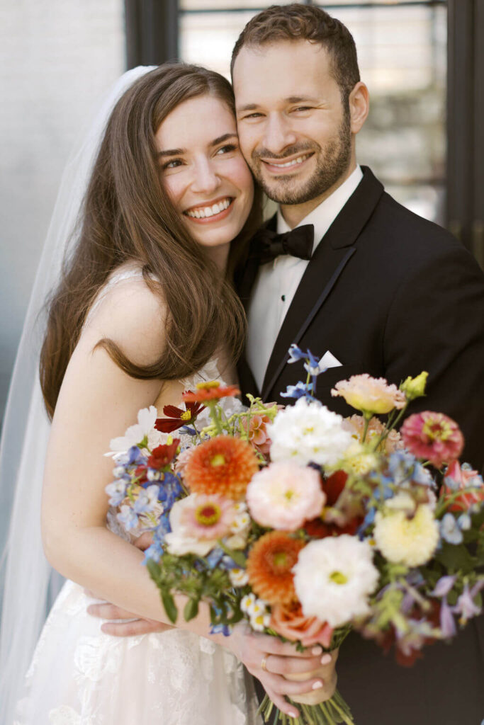 bride and groom smiling and holding bouquet by event coordinator madison wi