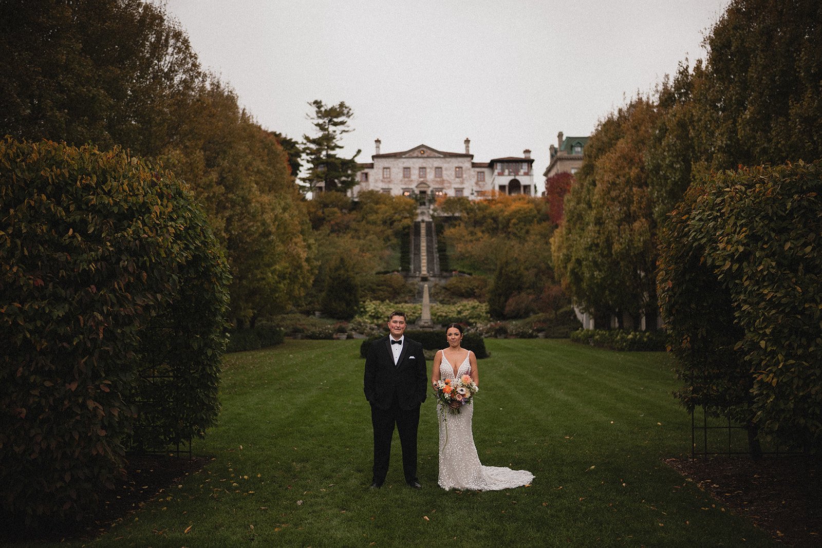 Bride and groom striking a pose in front of the villa terrace at their outdoor wedding venue