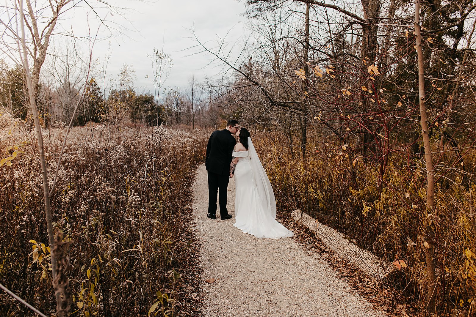 a couple stealing a kiss at the schlitz audobon nature center, one of the outdoor wedding venues in milwaukee