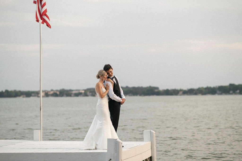 a couple posing near the water at their outdoor wedding venues near milwaukee