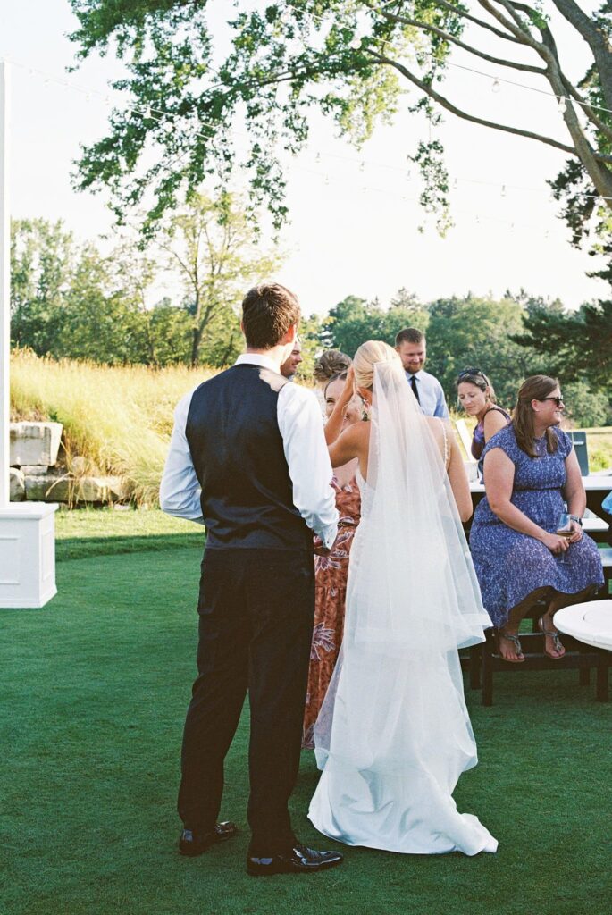 Bride and groom talking with guests at their dream outdoor wedding venue