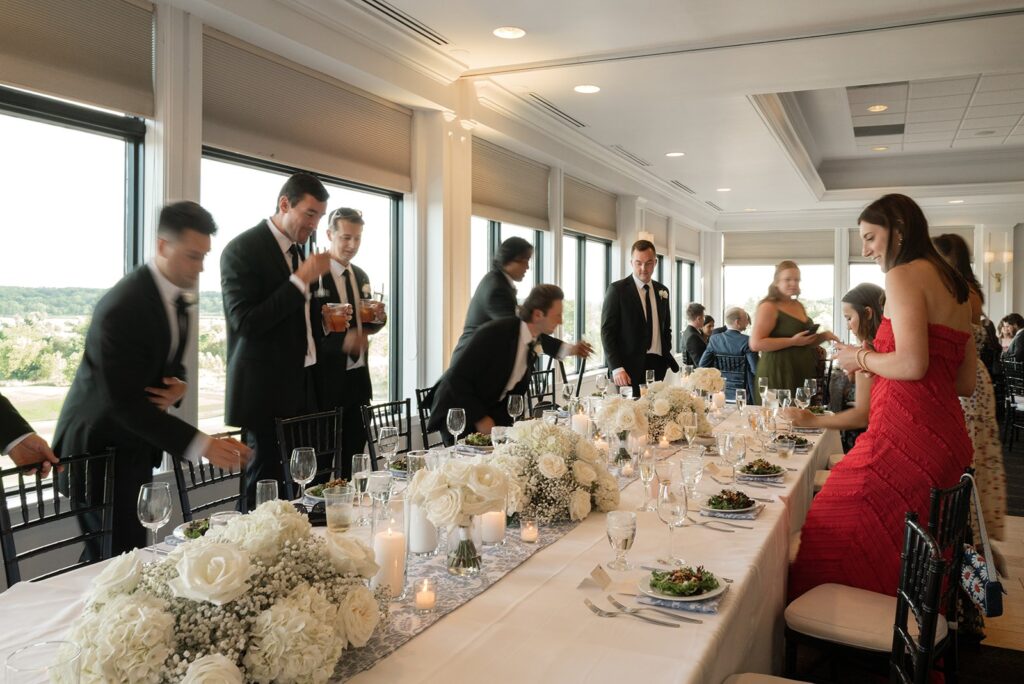 long table setting with guests gathering to be seated at a lake geneva small wedding venue