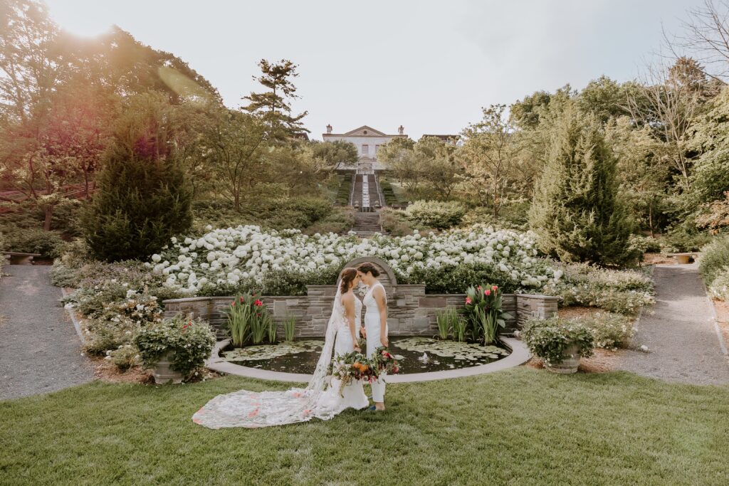 stunning wide shot image of brides at their lush outdoor lake geneva wedding location