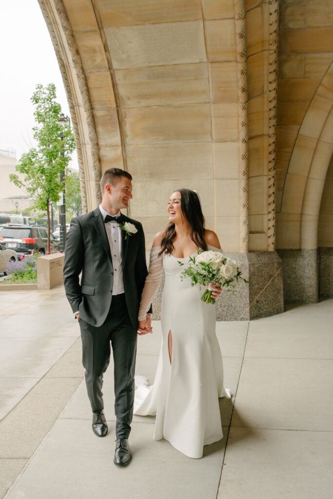 portrait of bride and groom walking hand-in-hand, laughing during their photoshoot at their lake geneva wedding