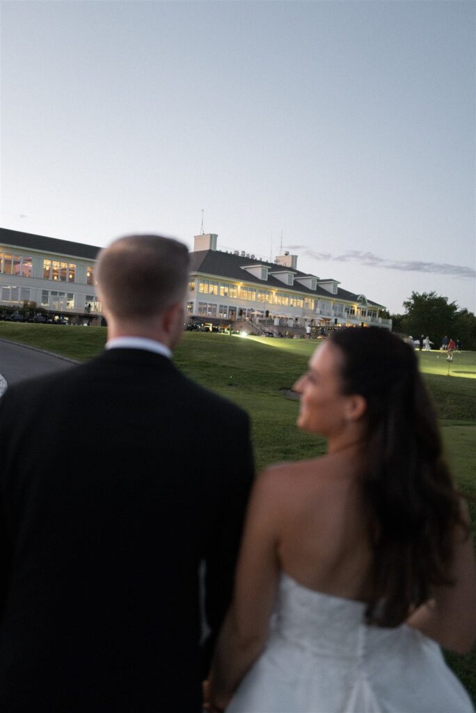 candid photograph of a bride and groom walking toward their lake geneva wedding reception venue