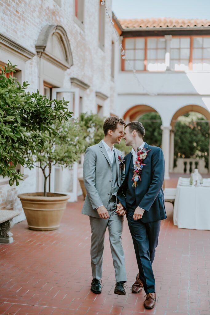 candid photograph of grooms sharing an intimate moment during their portrait shoot at their lake geneva wedding