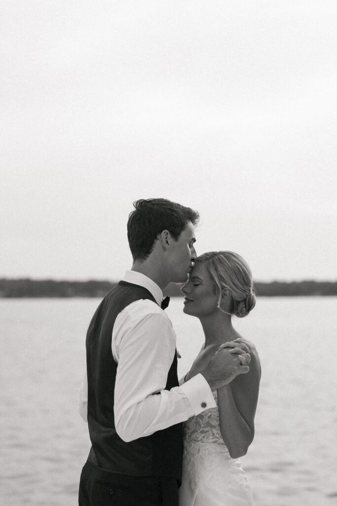 groom kissing bride on the forehead during their portrait shoot at their lake geneva wedding