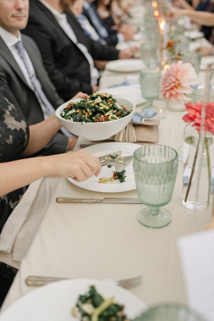 Guests enjoying a plated salad course at a long banquet table during a wedding reception at one of the most elegant wedding reception venues in Madison WI