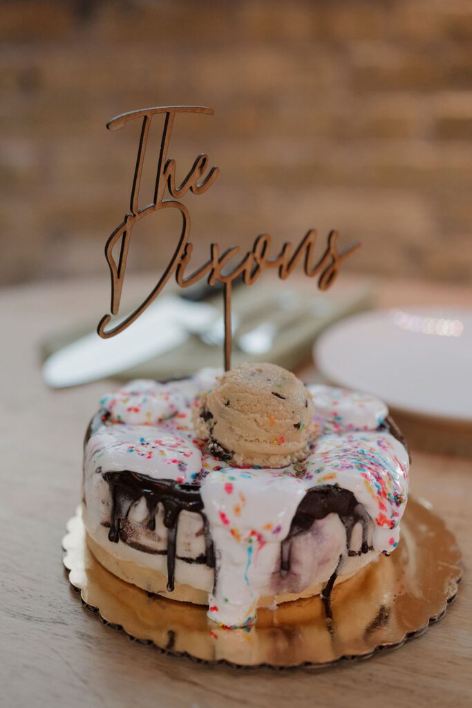 Custom wedding dessert with “The Dixons” topper displayed at a Madison WI wedding venue reception