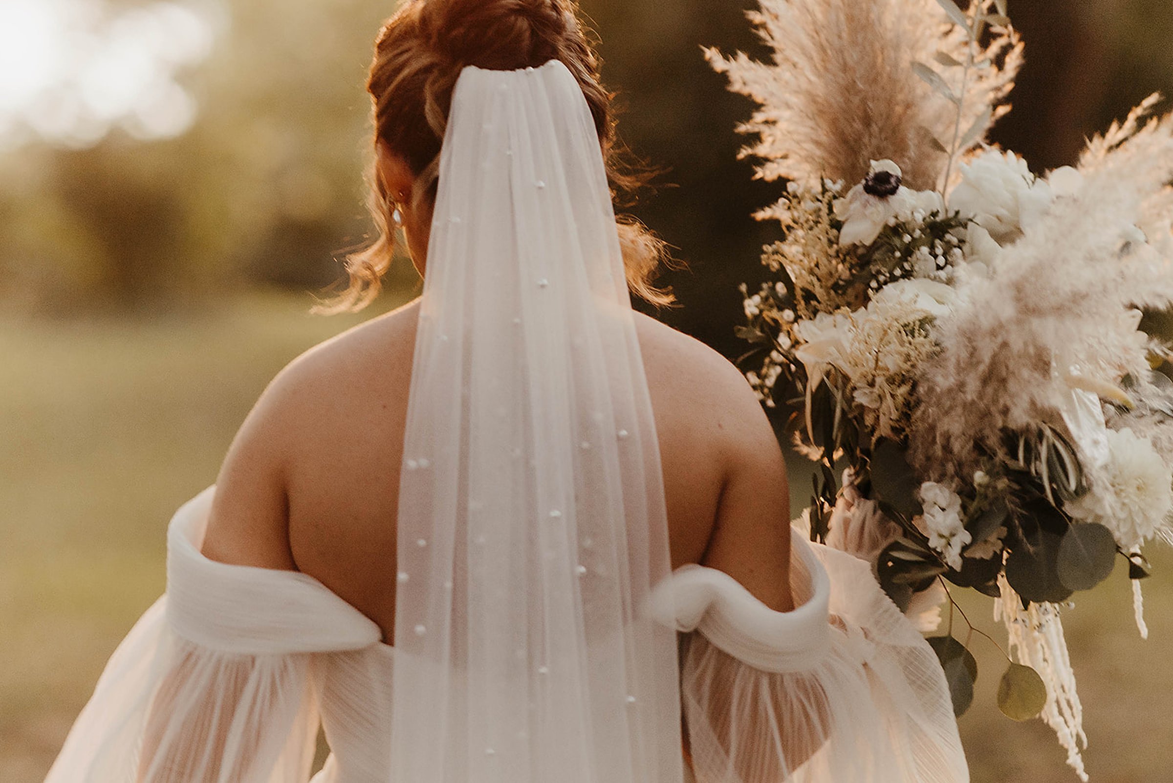 Bride holding a neutral floral bouquet during an outdoor Madison wedding at sunset