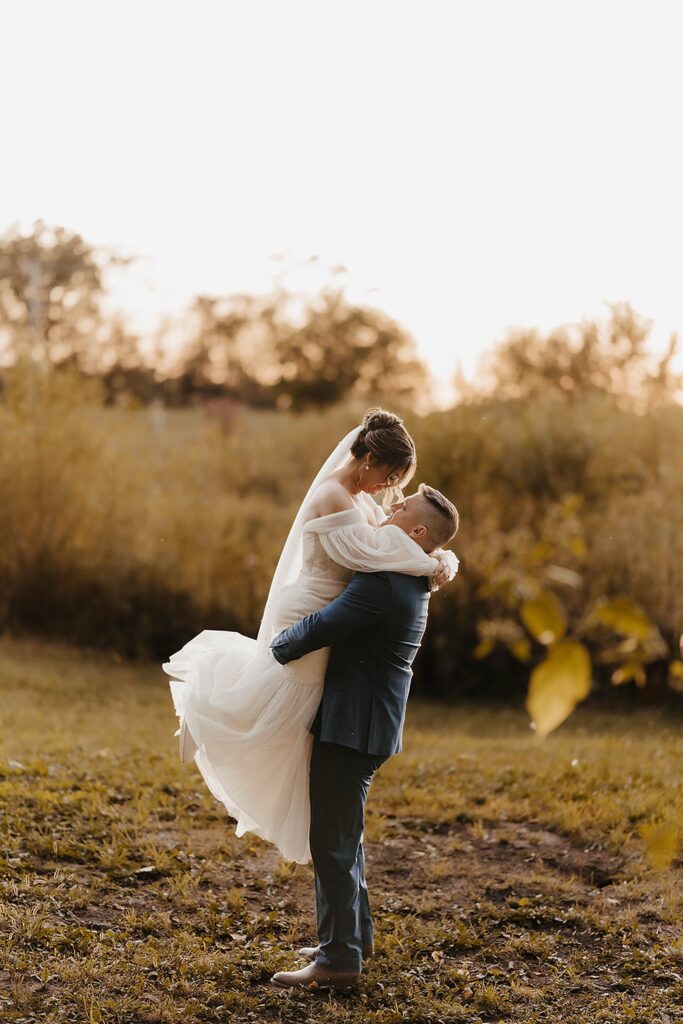 Bride and groom embracing during golden hour at an outdoor Wisconsin wedding venue