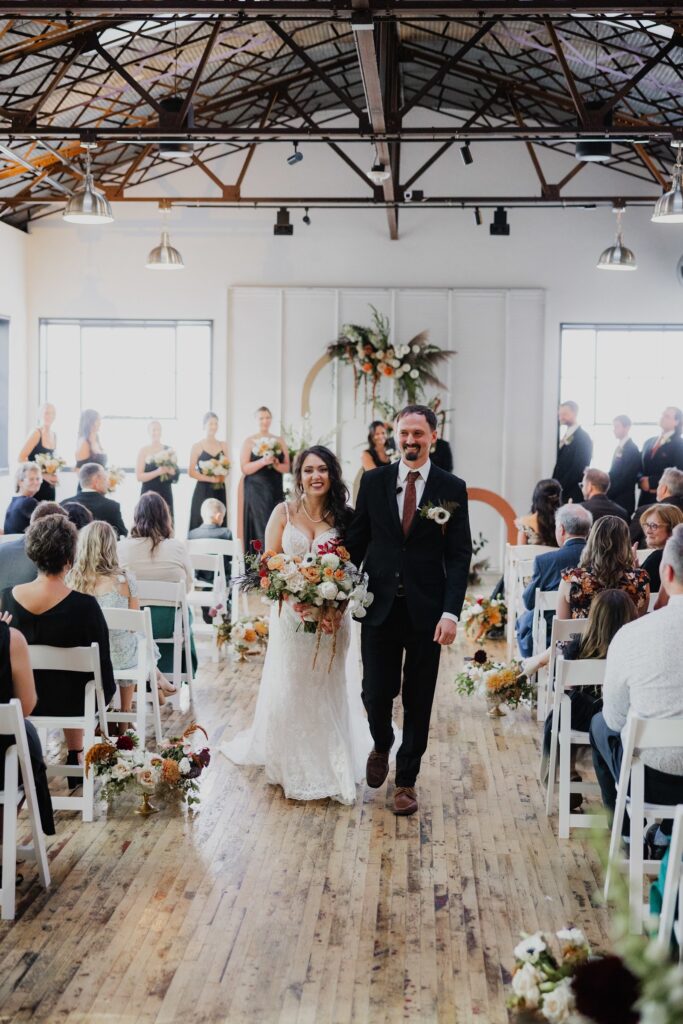 Newly married couple walking down the aisle after their ceremony at a wedding venue Madison WI couples love