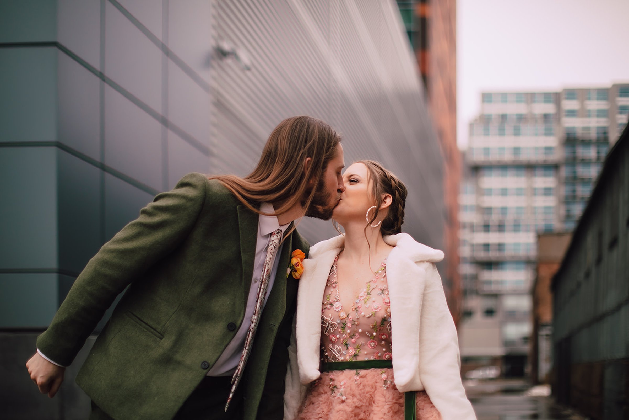 Couple kissing outside an industrial Madison wedding venue in downtown setting