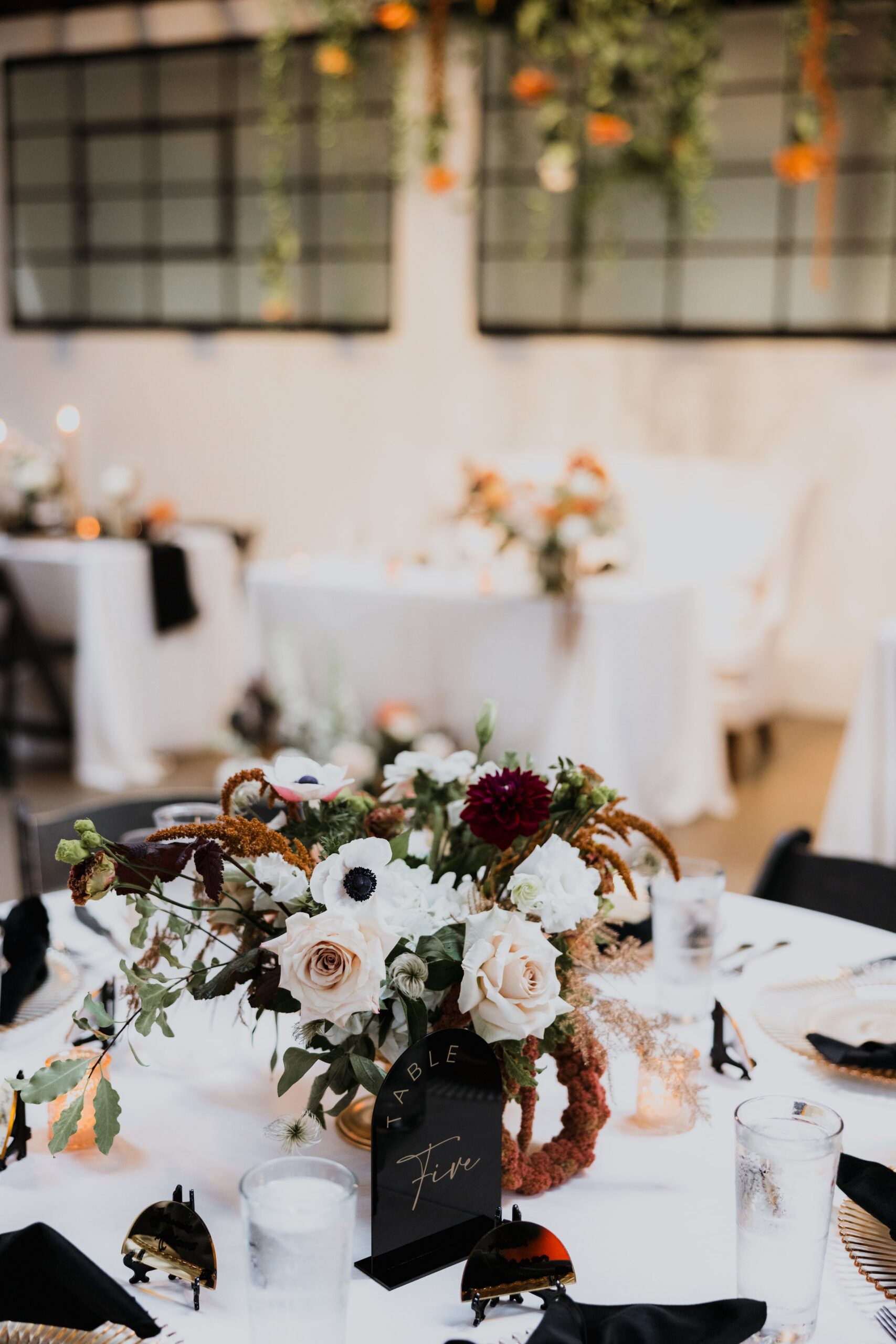 Elegant wedding reception table with floral centerpiece and candles set in a modern venue, showcasing stylish details often seen at weddings Madison WI and popular places to get married in Madison WI.